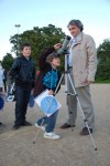 Un élémentaire regardant dans une longue vue avec un professeur positionné debout à côté de lui