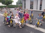 Des enfants faisant du tricycle dans la cour de récréation